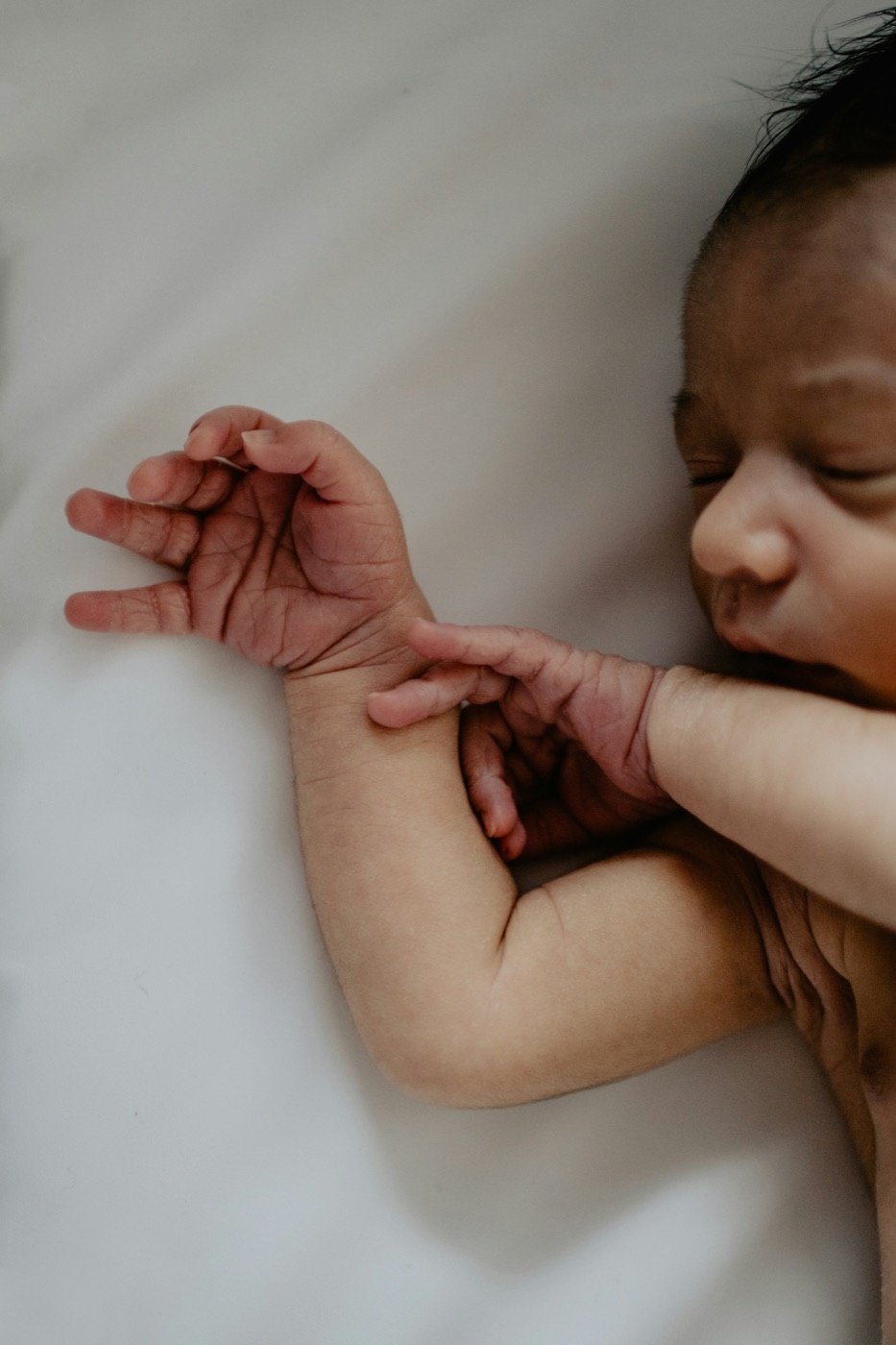 Newborn stretching small hands while resting
